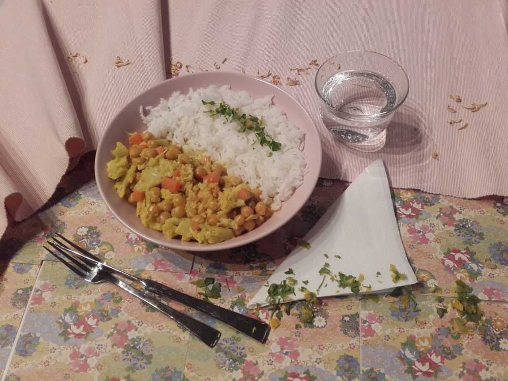 vegan cauliflower curry with chickpeas on a table with silverware