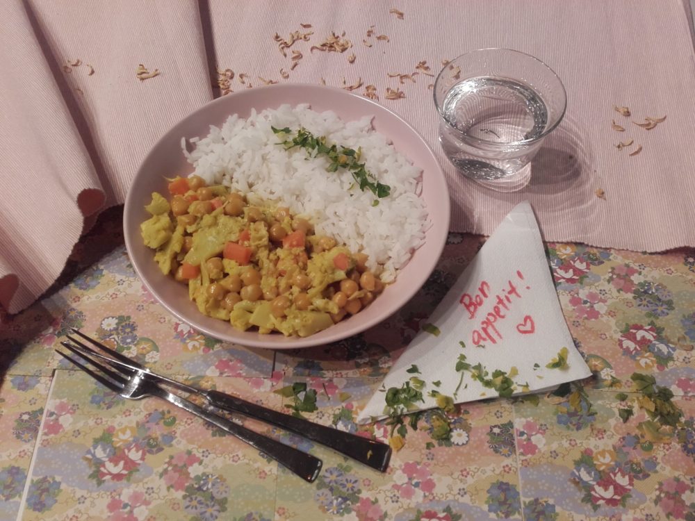 vegan cauliflower curry with chickpeas on a table with silverware