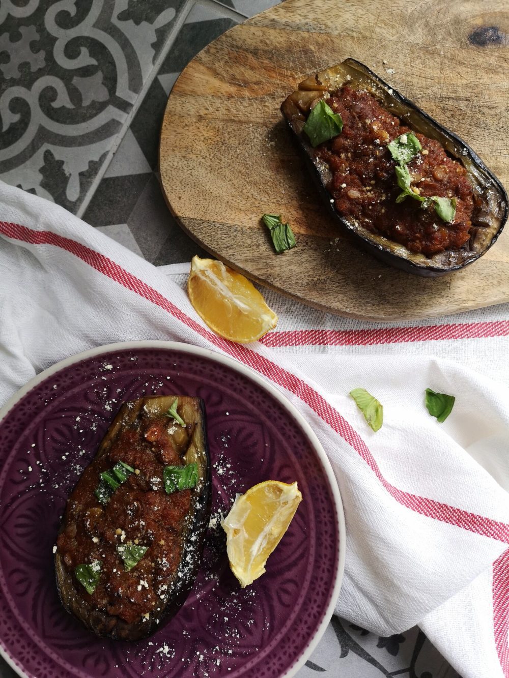 moroccan stuffed aubergine on a purple plate with lemon slices