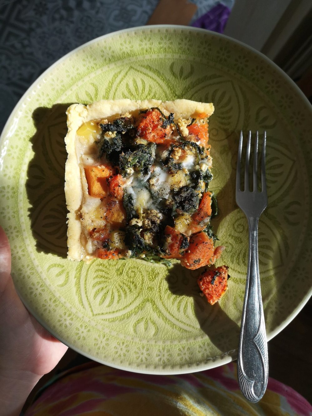 butternut squash quiche with spinach and feta on a green plate with a fork