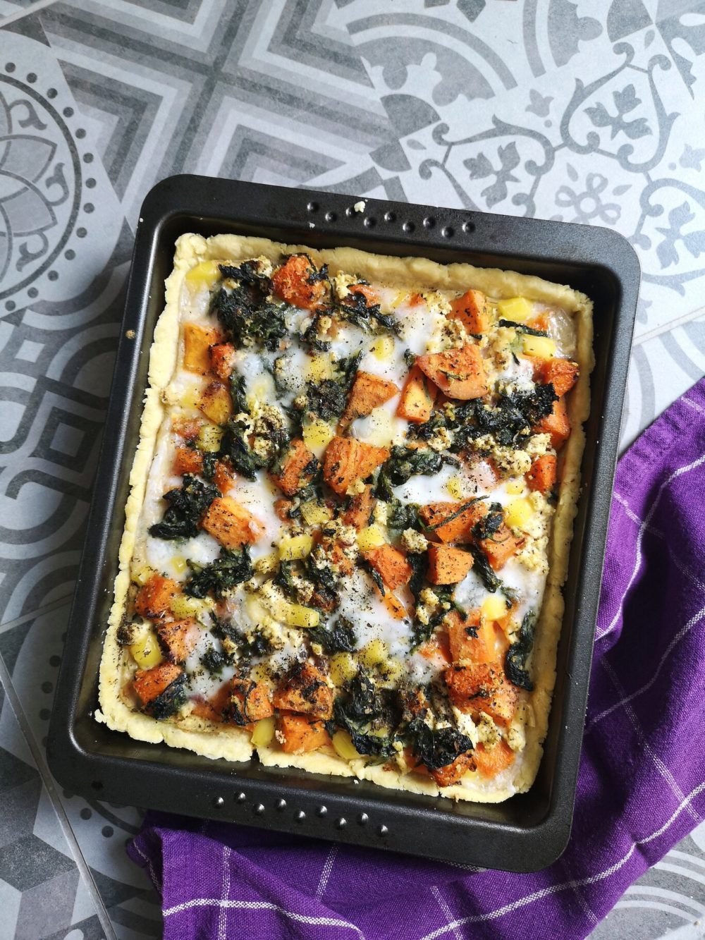 butternut squash quiche with spinach and feta on a green plate with a fork