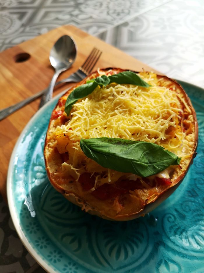 spaghetti squash on a blue plate with silverware