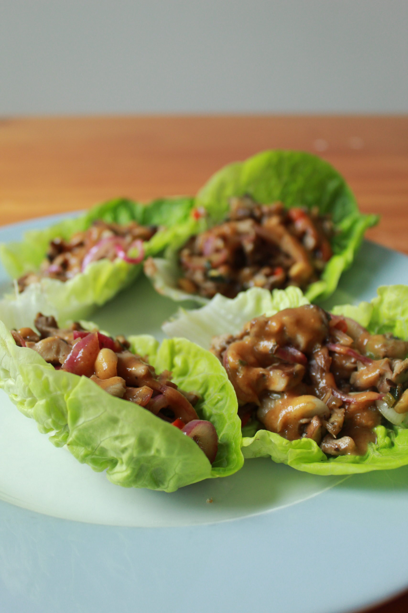 vegan mushroom larb lettuce boats on a white plate