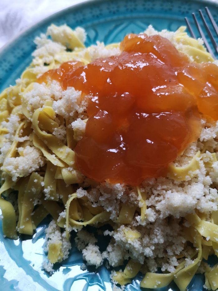 vegan hungarian noodles on a teal plate with a fork