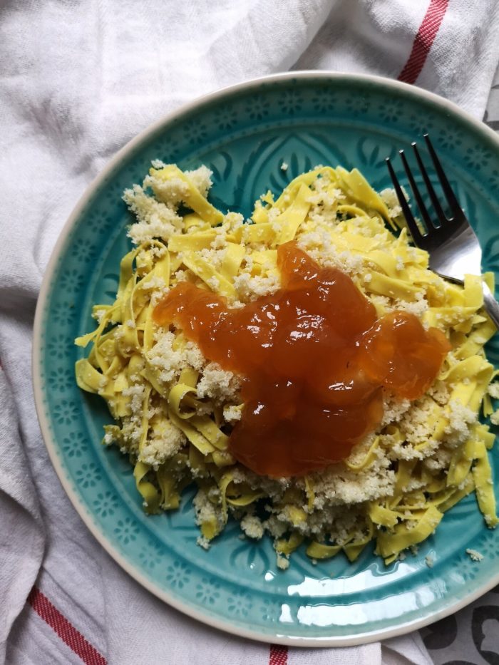 vegan hungarian noodles on a teal plate with a fork