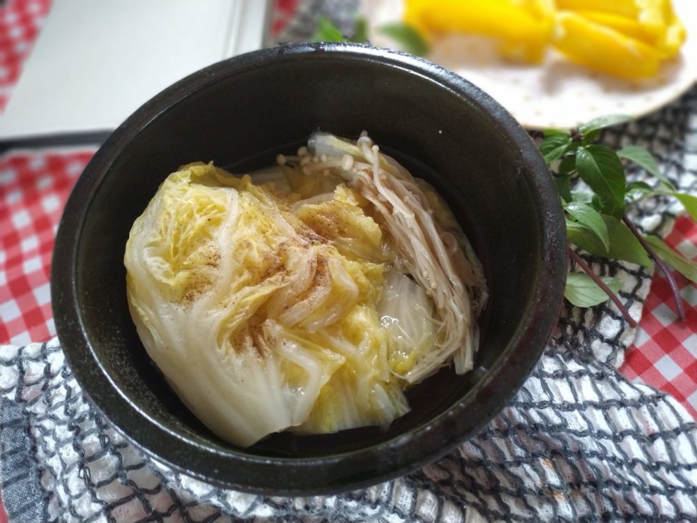 chinese cabbage and mushroom soup in a black bowl