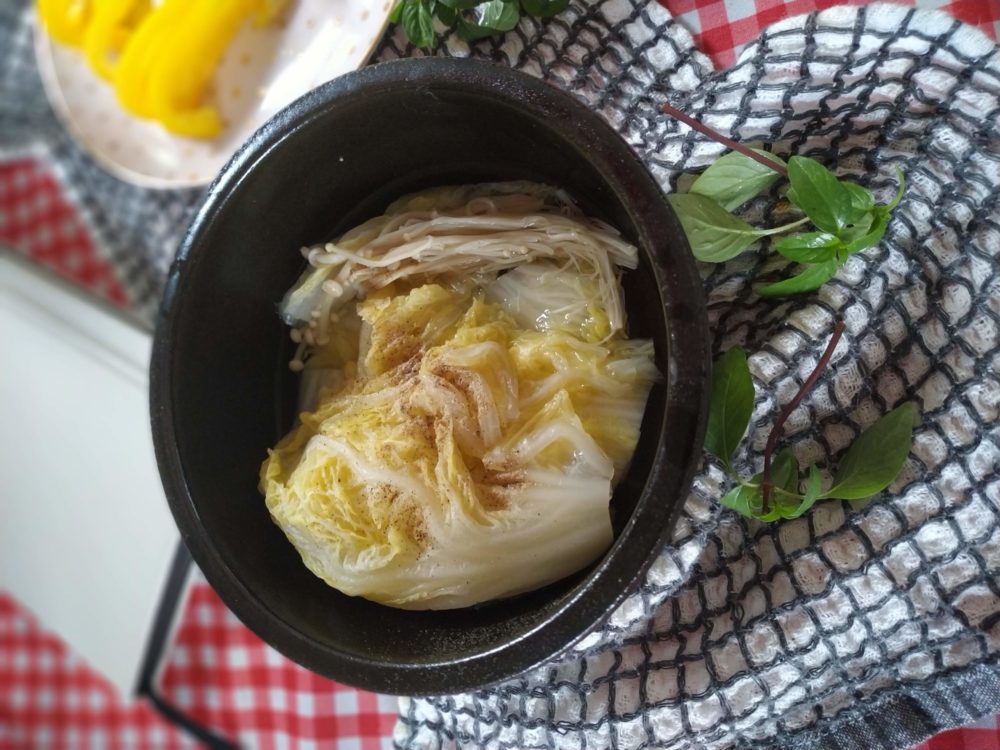 chinese cabbage and mushroom soup in a black bowl