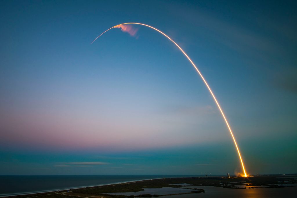 A Rocket launch at dawn over the ocean