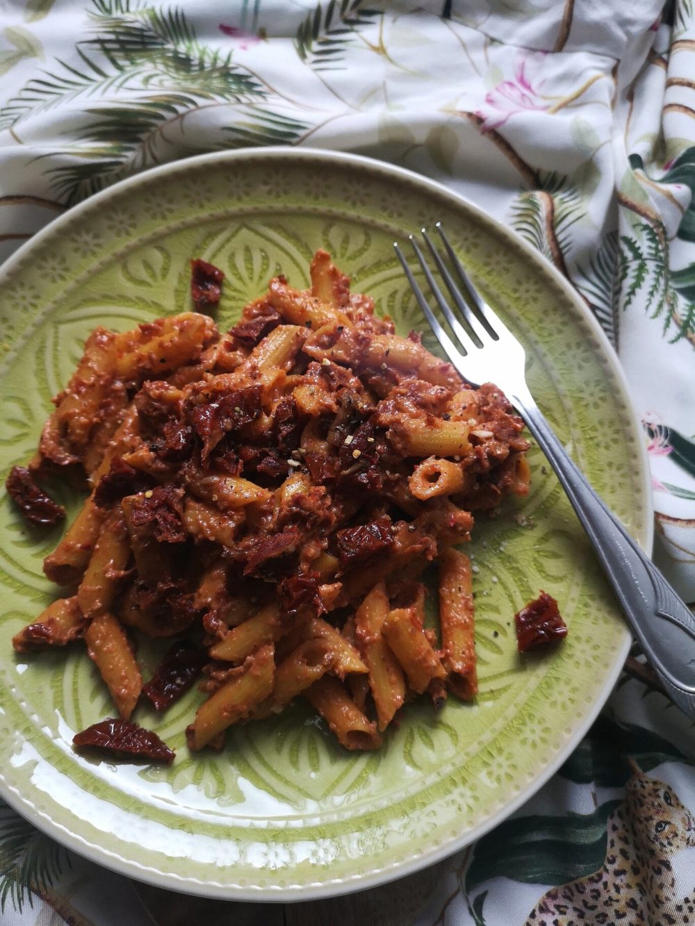 sundried tomato walnut pasta on a plate with a fork