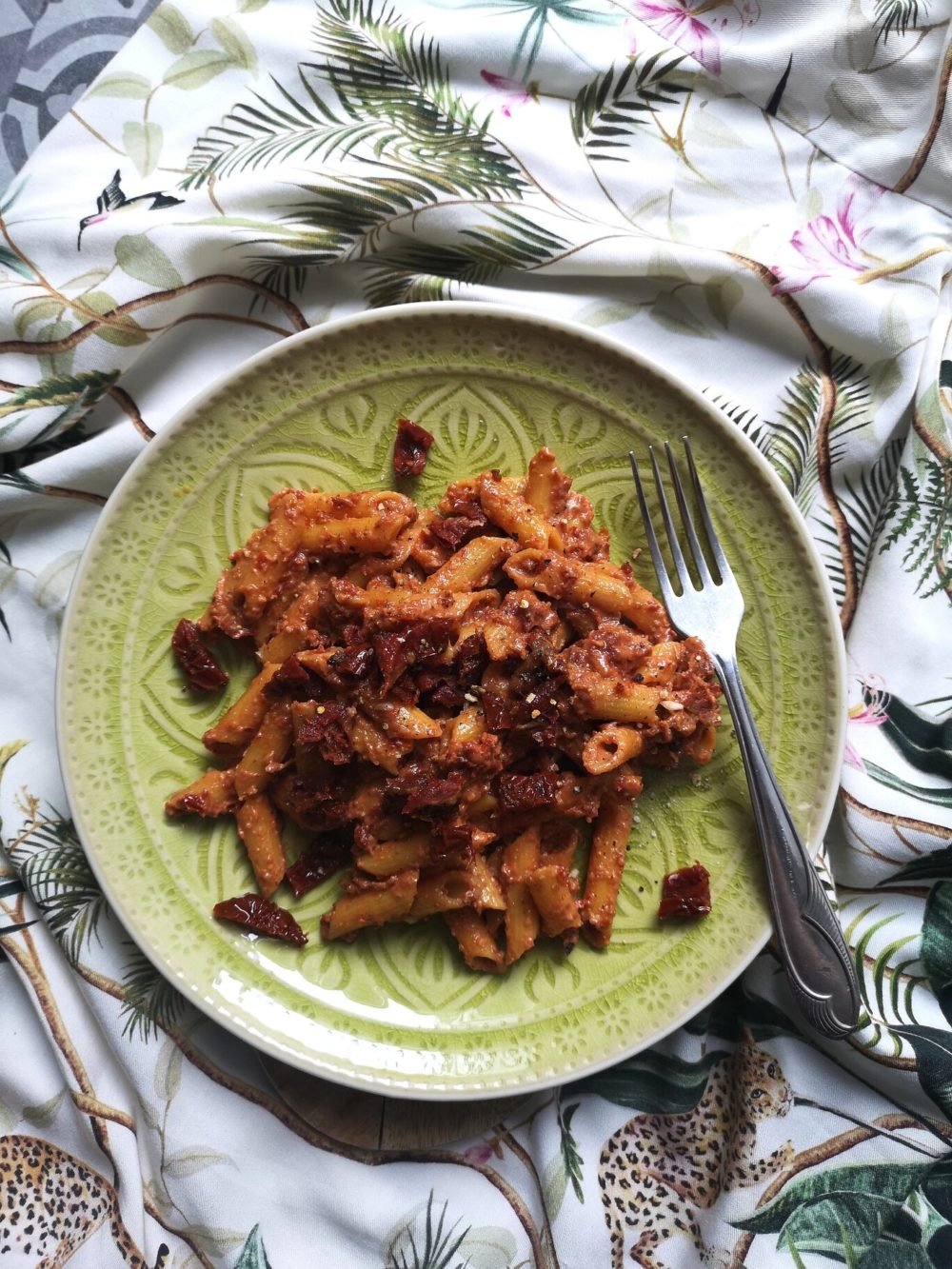 sundried tomato walnut pasta on a plate with a fork