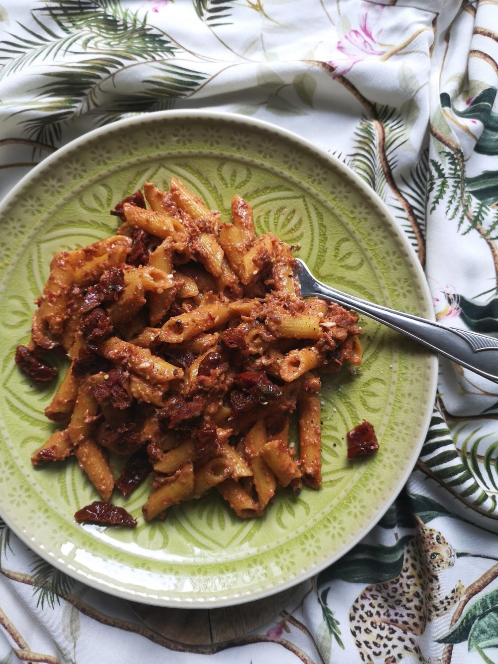 sundried tomato walnut pasta on a plate with a fork