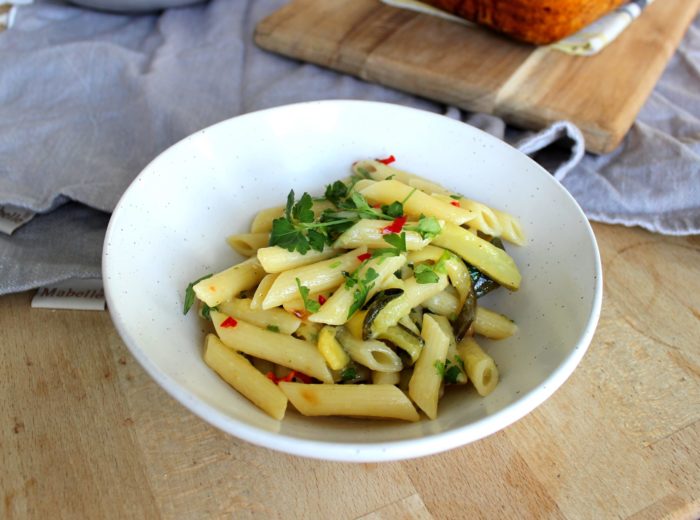 vegan zucchini and roasted lemon pasta in a white bowl on a table