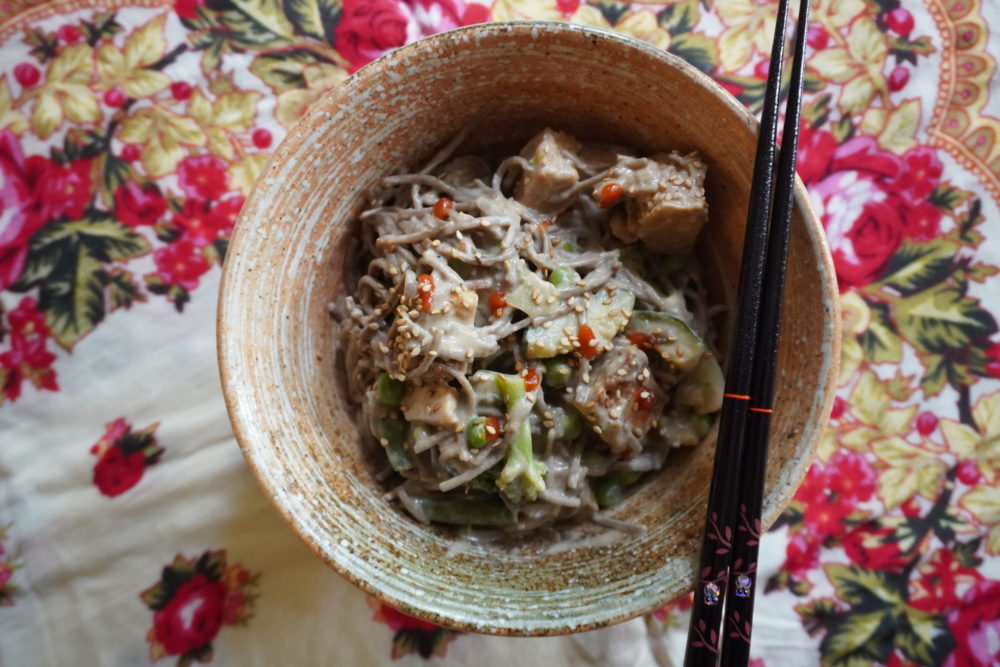 asian peanut soba noodles in a dish with a floral background