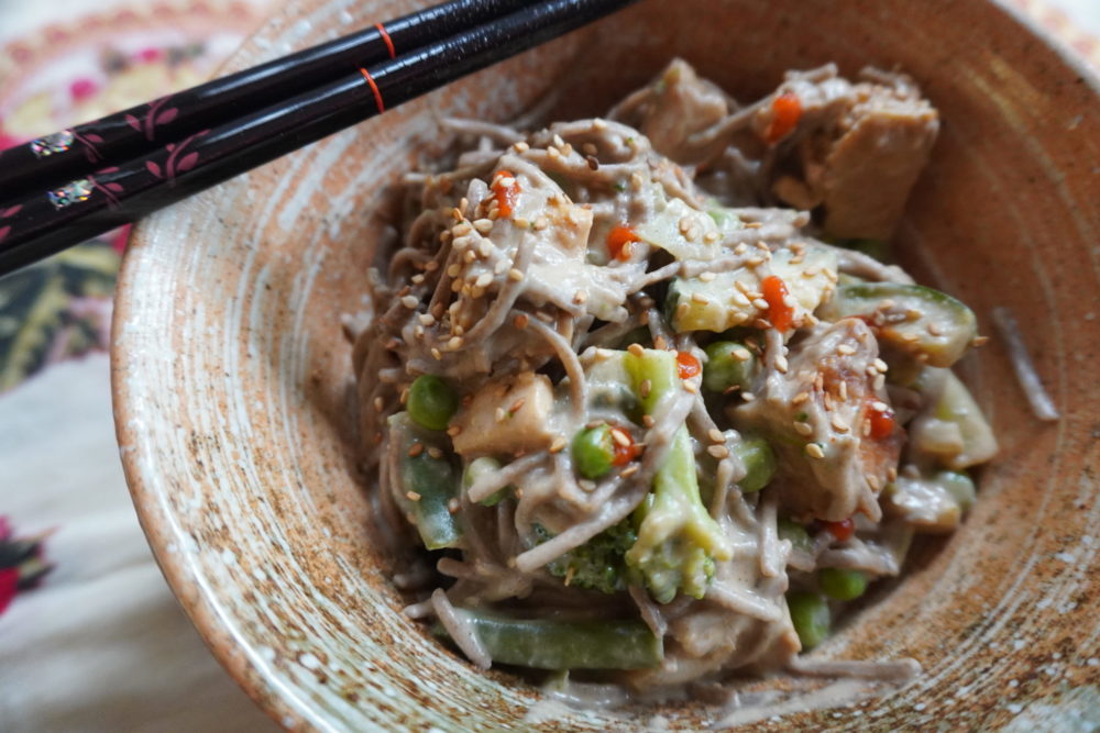 asian peanut soba noodles in a dish with a floral background