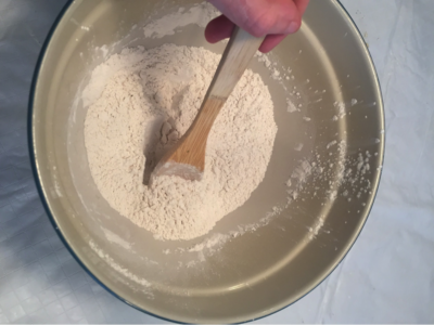 flour in a bowl with a wooden spoon