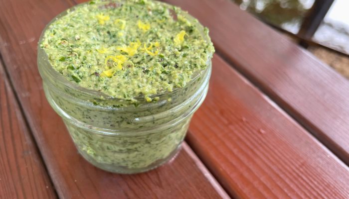 jar of kale lemon pesto on a red table