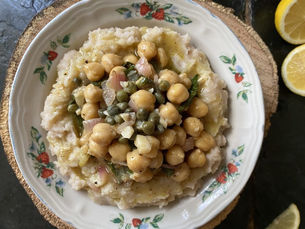 vegan chickpea picatta in a dish against a brown and black background