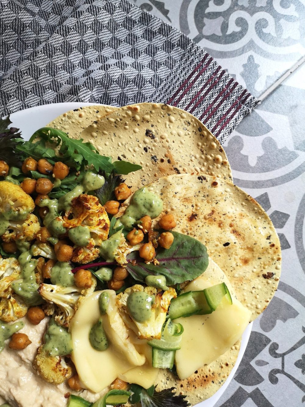 cauliflower shawarma on a white plate against a gray and white patterned background