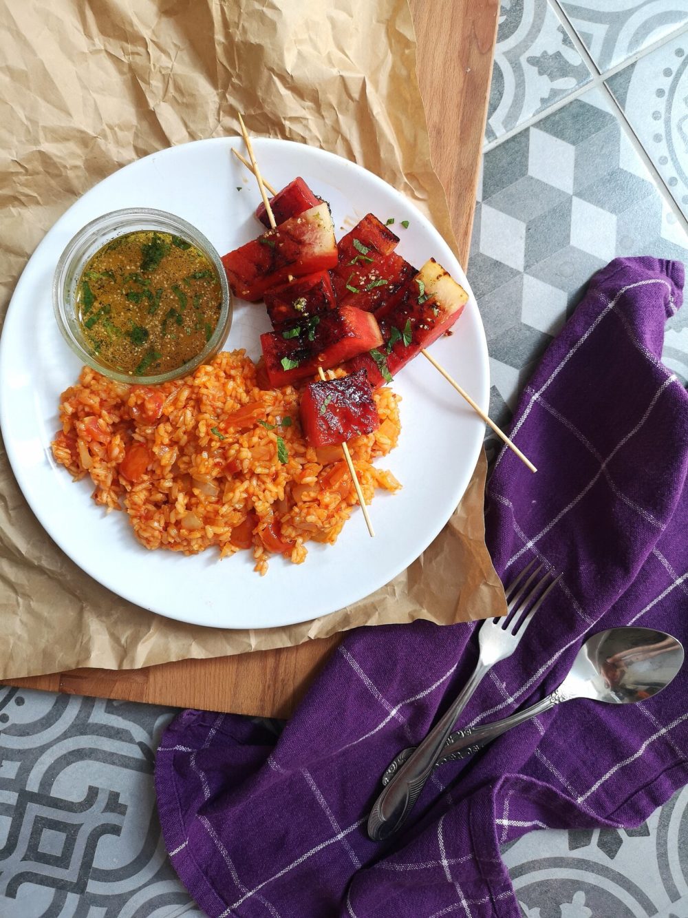 grilled watermelon and turkish rice on a white plate next to silverware