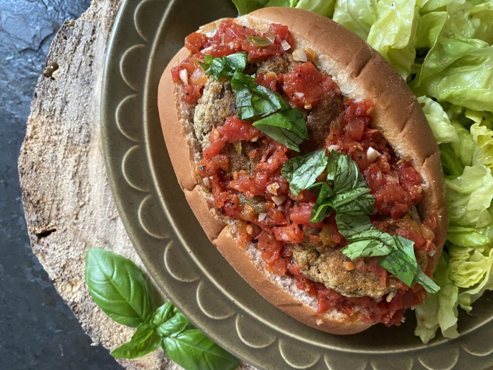 vegan eggplantball sub on a plate with a brown and black background