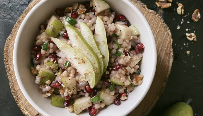 pomegranate pear couscous salad with dark background