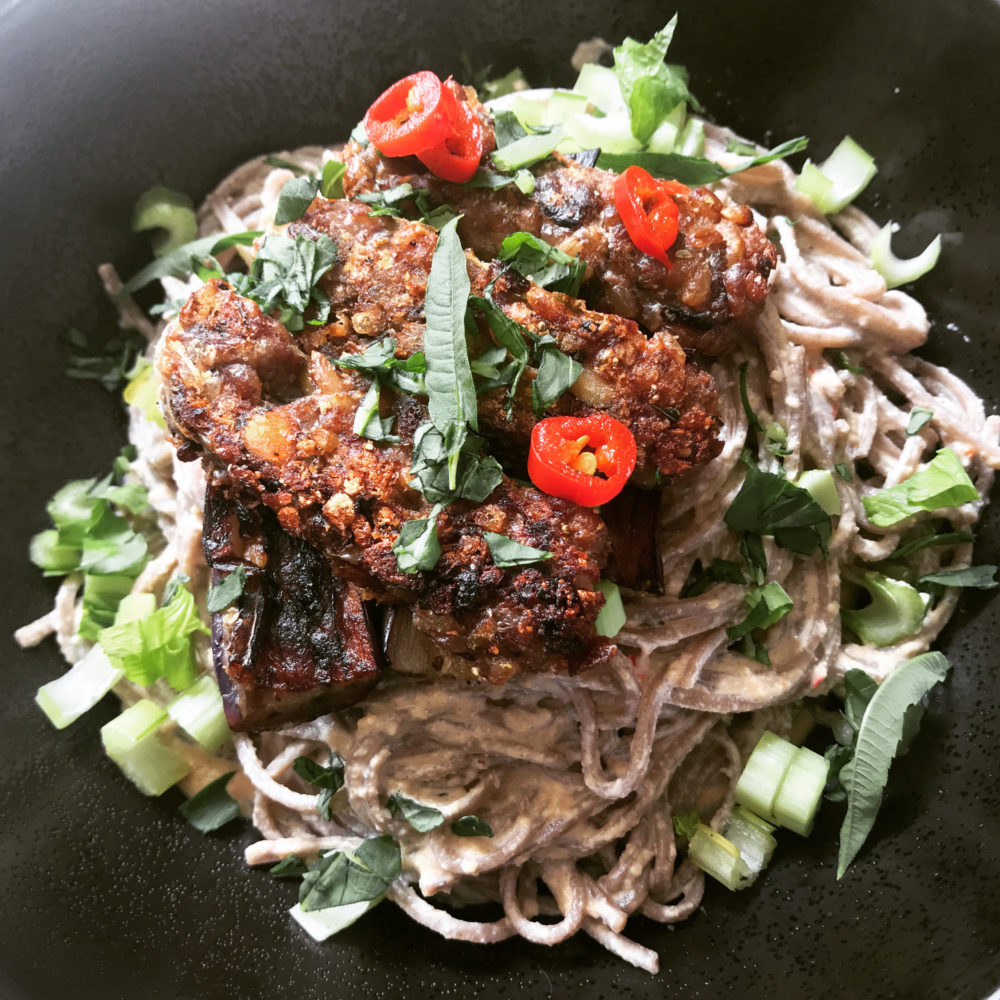 tempeh harissa noodles with a dark background