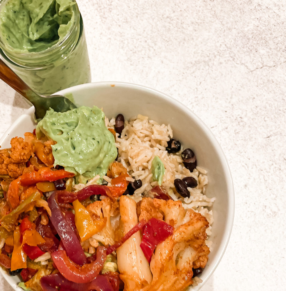 cauliflower fajita bowl topped with avocado crema