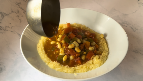 heirloom bean stew in a white dish on a white and gray marble tabletop