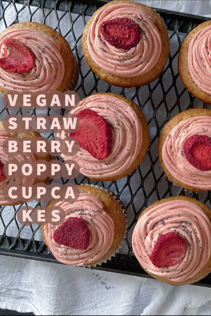 vegan strawberry poppy cupcakes on a wire cooling rack with caption