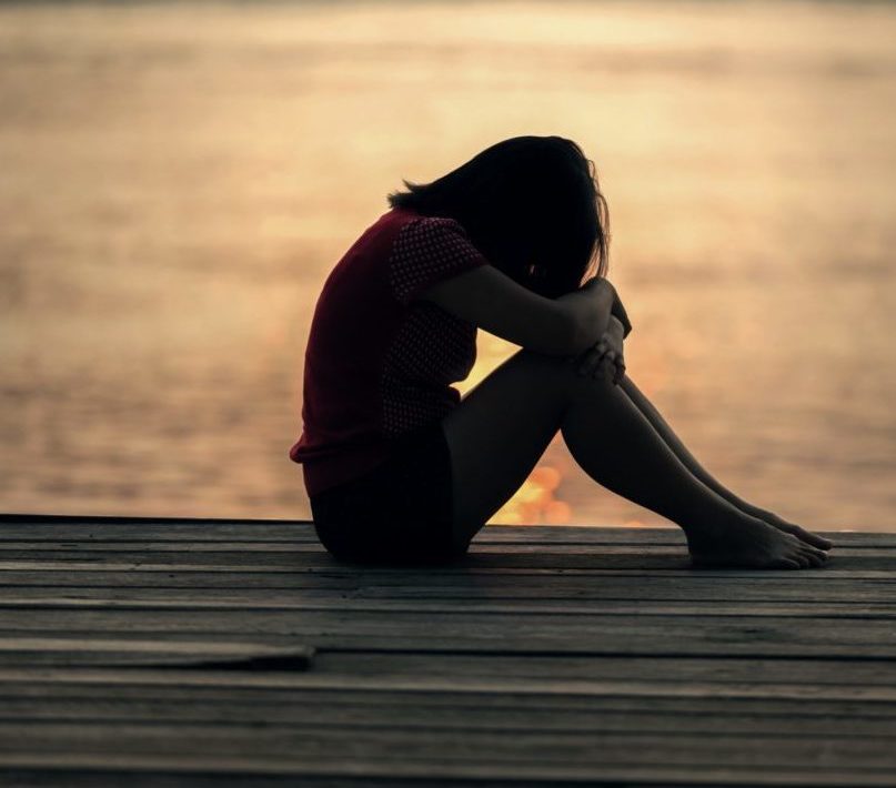 photo of woman crying on a dock