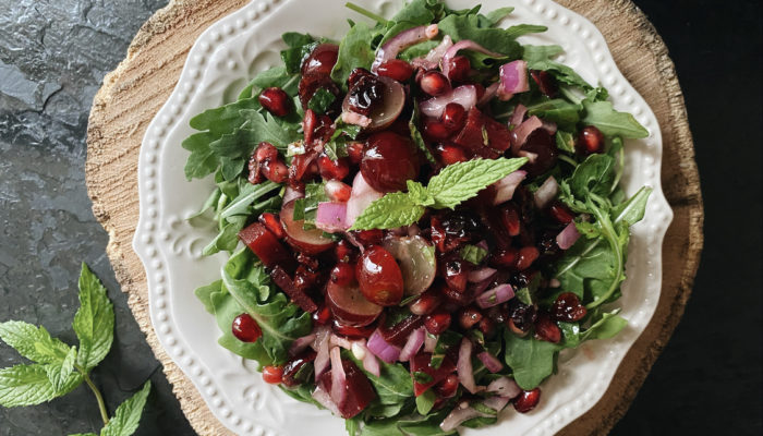 purple power salad on a white plate against a black and brown background