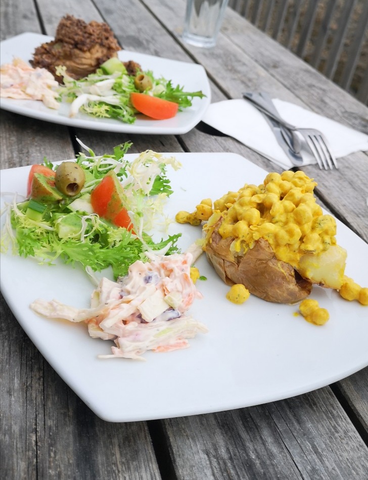 two white plates of food on a wooden picnic table