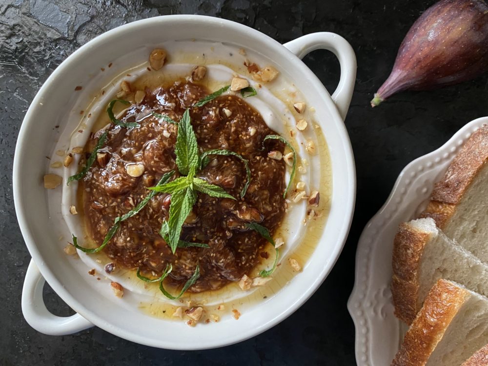 balsamic fig vegan feta dip in a white dish against a black background