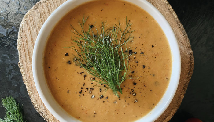 roasted fennel tomato soup in a white bowl against a brown and black background