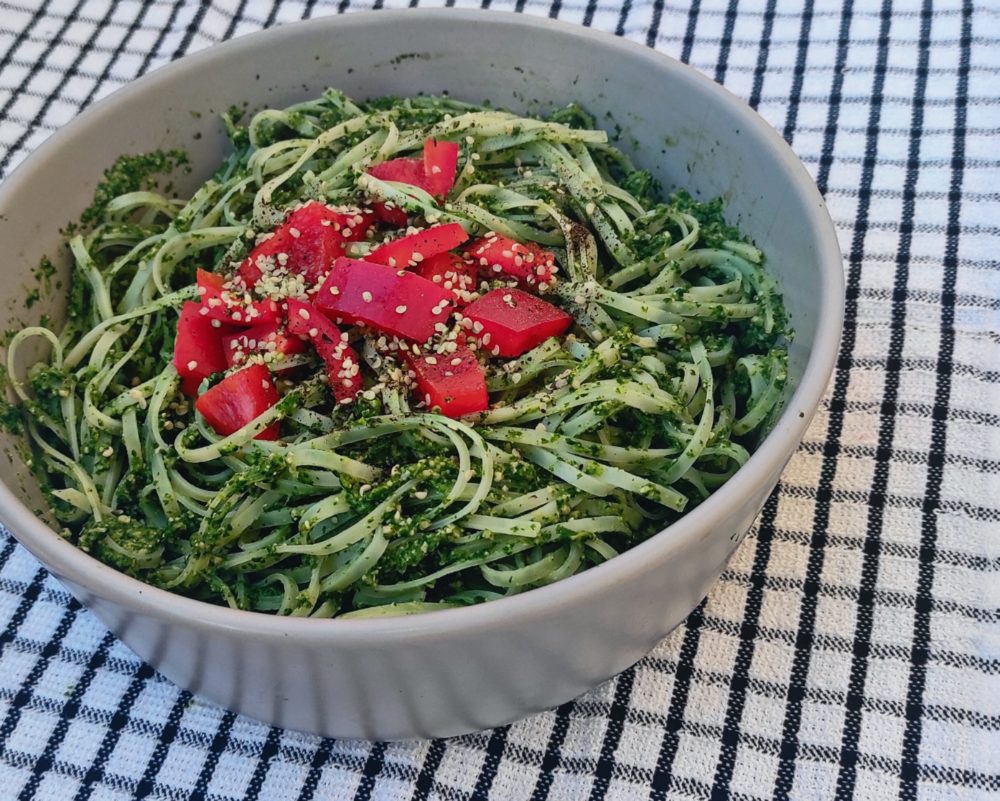 green goddess noodles in a white bowl against a black and white background