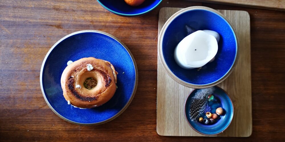 vegan breakfast bagel burger on a blue plate on a wooden table top