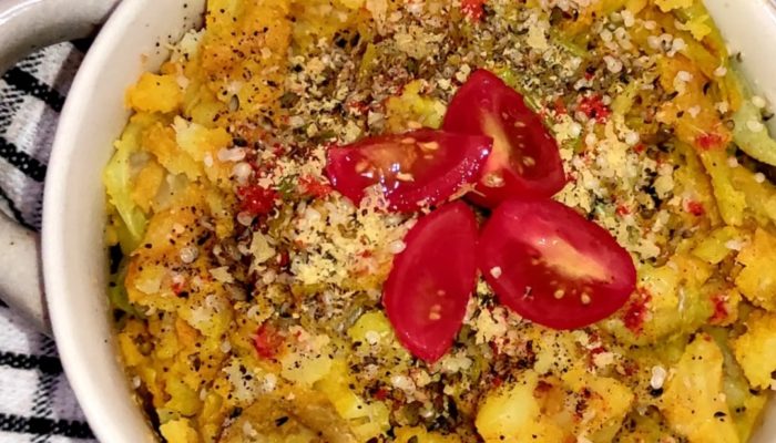 curried colcannon in a while dish with a black and white fabric background