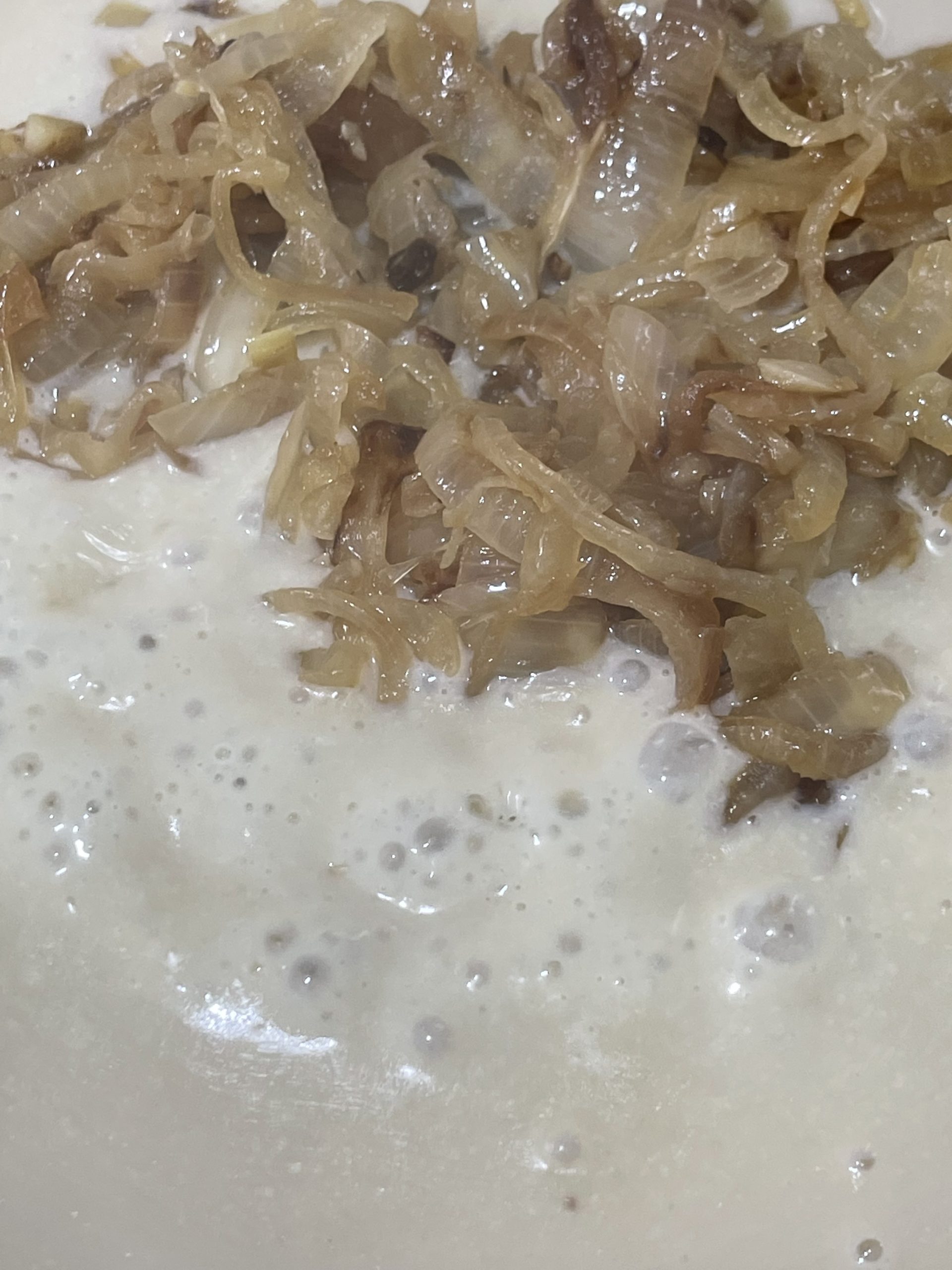 caramelized onions added to simmering white sauce