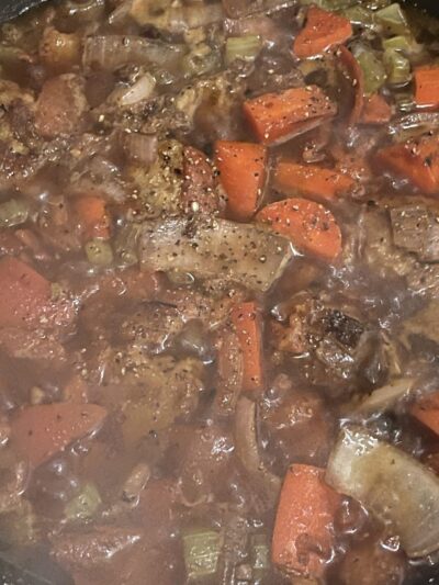 simmering vegan beef stew with ground black pepper