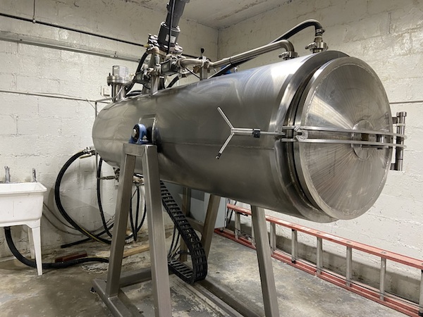 stainless steel machine in the shape of a large cylinder in a spare room. 