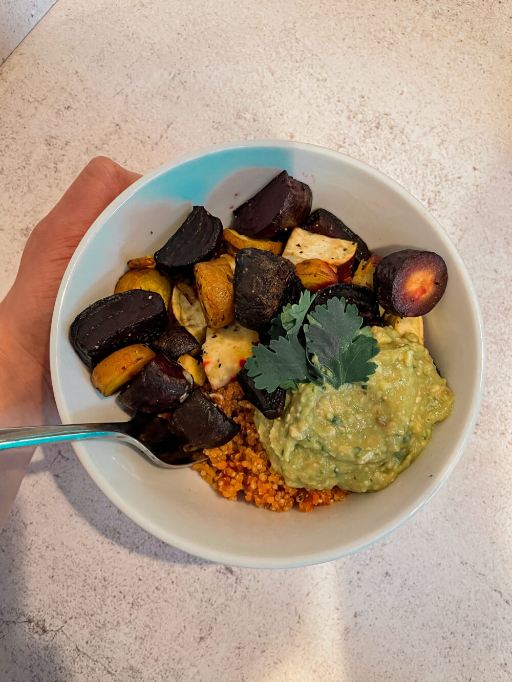 root veggie bowl with a hand holding it