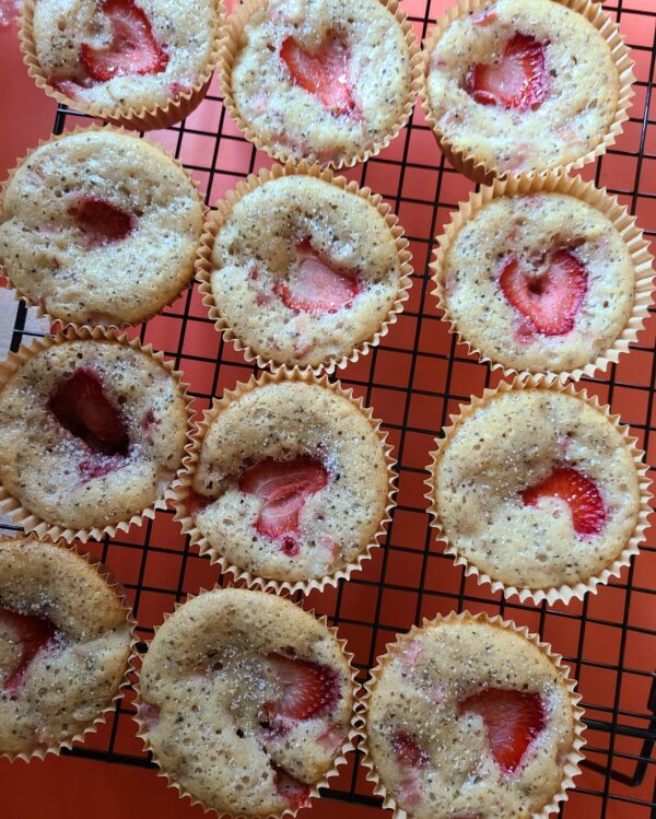 fresh strawberry rhubarb muffins on a black cooling rack