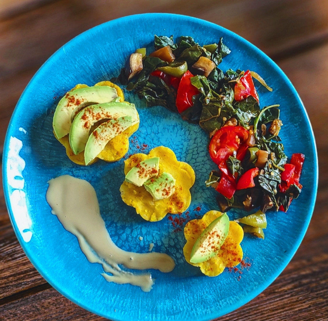 turmeric mashed potato shaped into flowers and placed artistically on a blue plate.